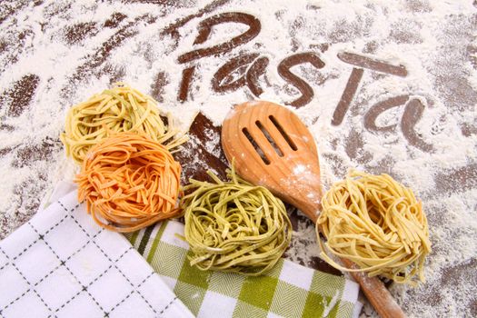Assortment of colored italian pasta on flour