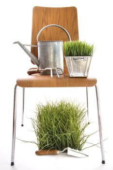 Garden tools, watering can on wood chair with white background
