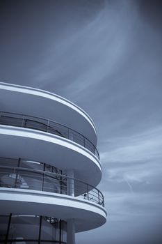 An Art-deco balcony against a blue sky toned blue