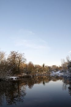 A view of a lake in winter with snow