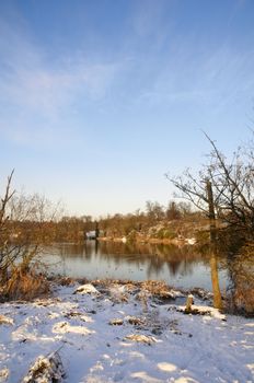 A view of a lake in winter with snow