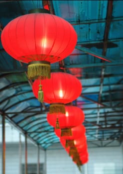Red lantern, shining, typical Chinese decorations for new year. Hanged under the blue roof.