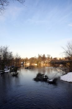 A view of a lake in winter with snow