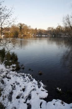 A view of a lake in winter with snow