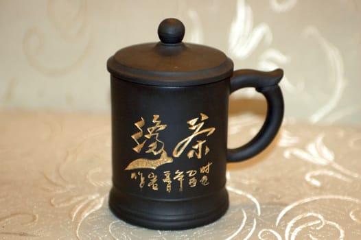 Traditional Chinese mug with special cover on top for brewing green tea.