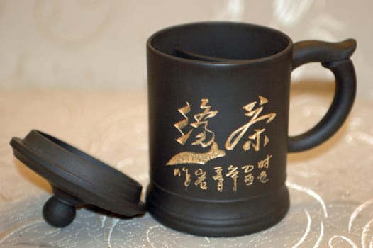 Traditional Chinese mug with special cover on top for brewing green tea.