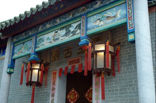 China - special decoration to temple entrance with simple paintings, colorful signs and traditional lanterns.