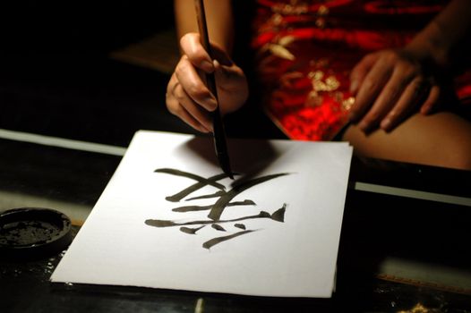 Chinese handwriting, art of calligraphy. Sign Ai - means LOVE. Written by femal in traditional Chinese dress.