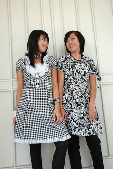 two sisters get posed in front of an old door