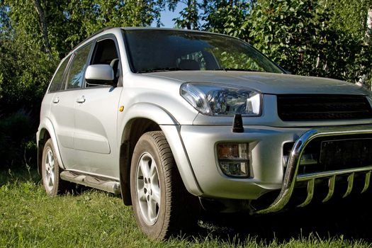 Silver colored SUV car on the green grass