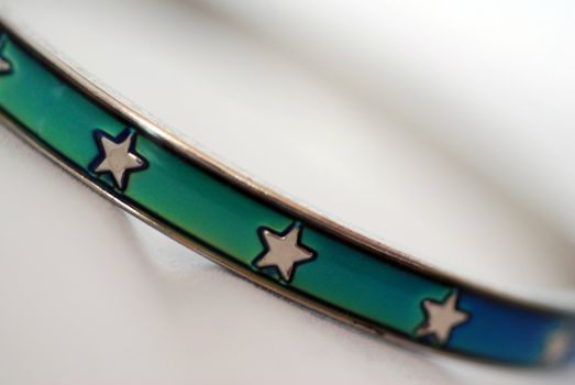 An extreme close up photograph of a turquoise bracelet with stars