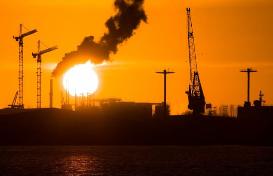 Industry silhouettes, pollution and big yellow sun