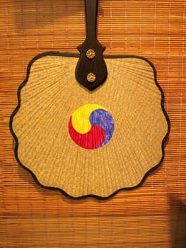 a traditional korean fan hanging on a wall