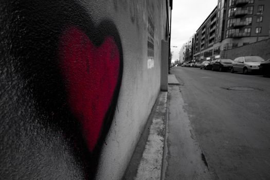 Heart sprayed grafitti on a wall in urban setting