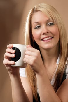 Happy and smiling female drinking coffee in an urban café.
