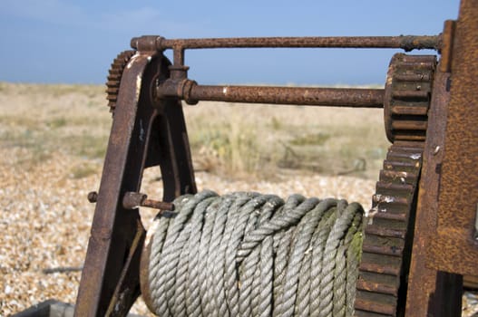 An old winch  with some rope on the drum