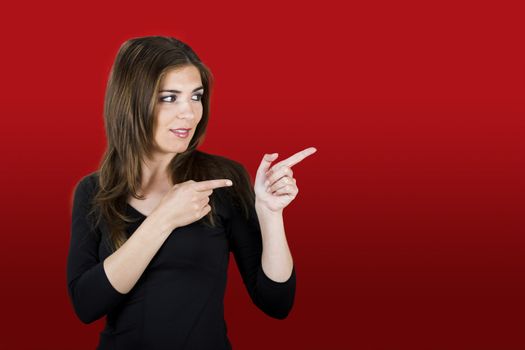 Beautiful woman in red showing a direction with her hands