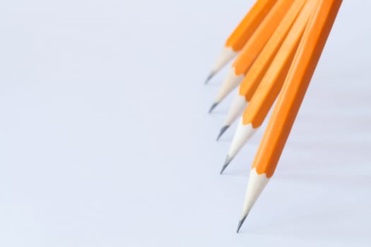 Few wooden yellow pencils standing in a row on gray background with copy space