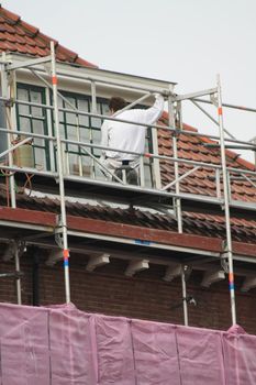 A painter working on a covered scaffolding