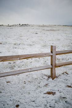 New cedar split rail fence, shot on a winter morning, under a sunless sky.