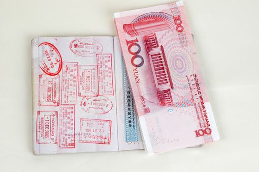 Passport full of stamps from China and Hongkong borders together with Chinese money, RMB banknotes.