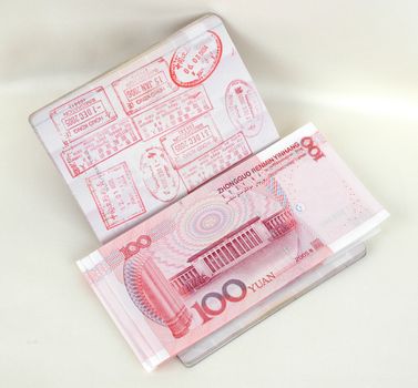 Passport full of stamps from China and Hongkong borders together with Chinese money, RMB banknotes.