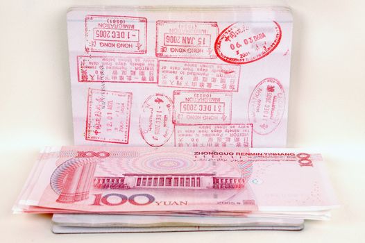 Passport full of stamps from China and Hongkong borders together with Chinese money, RMB banknotes.