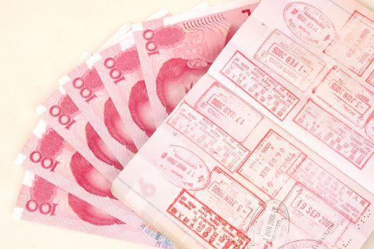 Passport full of stamps from China and Hongkong borders together with Chinese money, RMB banknotes.