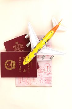 Passport and small toy plane as travelling symbols.