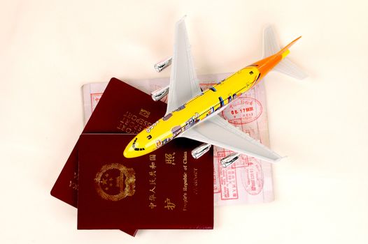 Travelling symbols: passports, stamps from China and Hongkong customs, small plane.