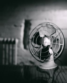 Electric room fan with a heat radiator in the background.