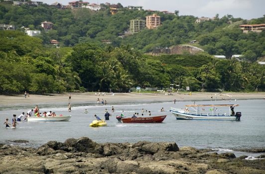 People and boats in the water at Playa Hermosa Costa Rica 