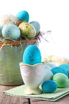 Festive easter scene with turquoise speckled egg in cup