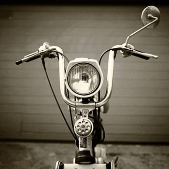 Classic 70's scooter, in front of garage door.