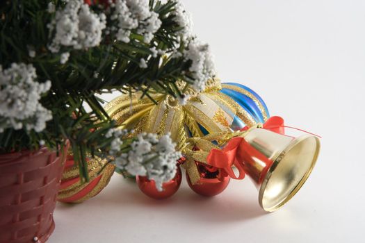 Christmas spheres and handbell under a fur-tree