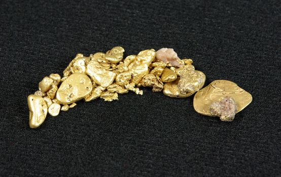 Many large gold nuggets spread across a dark background.
