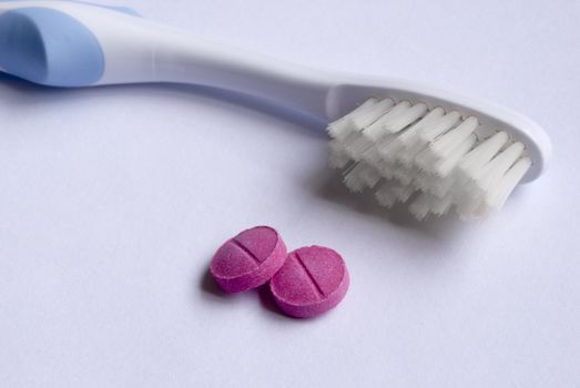 tooth brush and two dental disclosing tablets