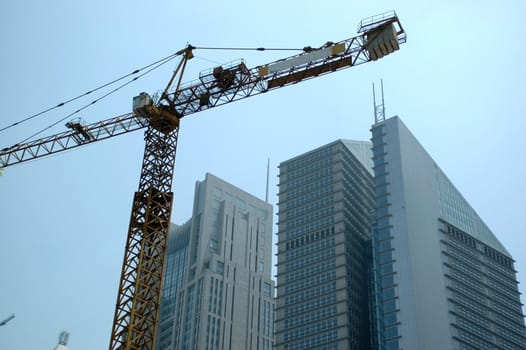 China, Shanghai. Finished modern office buildings together with crank. New skyscrapers still under construction.