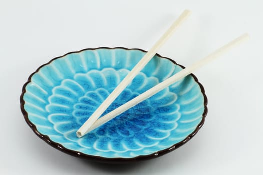 Chopsticks on Blue Plate