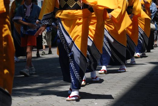 Line of Japanese ladies in Summer kimonos walk towards the camera