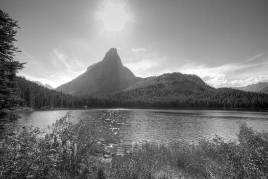 A mountain lake with sun in black and white.