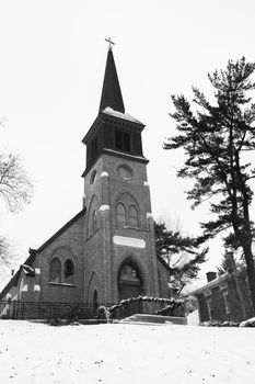 This old church sits on a hill and is blaneted by winter snow.