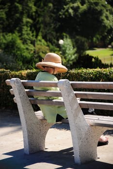 Woman sitting and reading on a park bench.