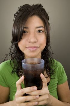 Portrait of a Latina with a cup of iced soda.