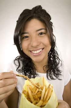 Portrait of a teenage Latina with fries.