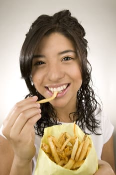 Portrait of a teenage Latina with fries.