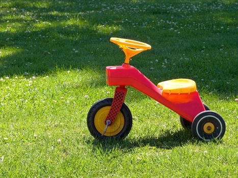 Bright colorful Tricycle standing on the grass
