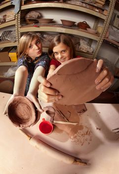 Cute young girls working on projects in a clay studio