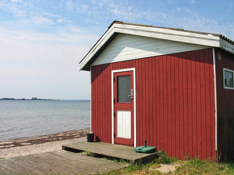 Small beautiful red summerhouse by the sea