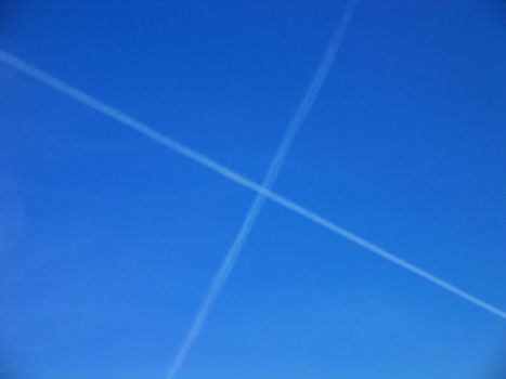 Aerial crossroad clear blue sky with crossing jets contrails
